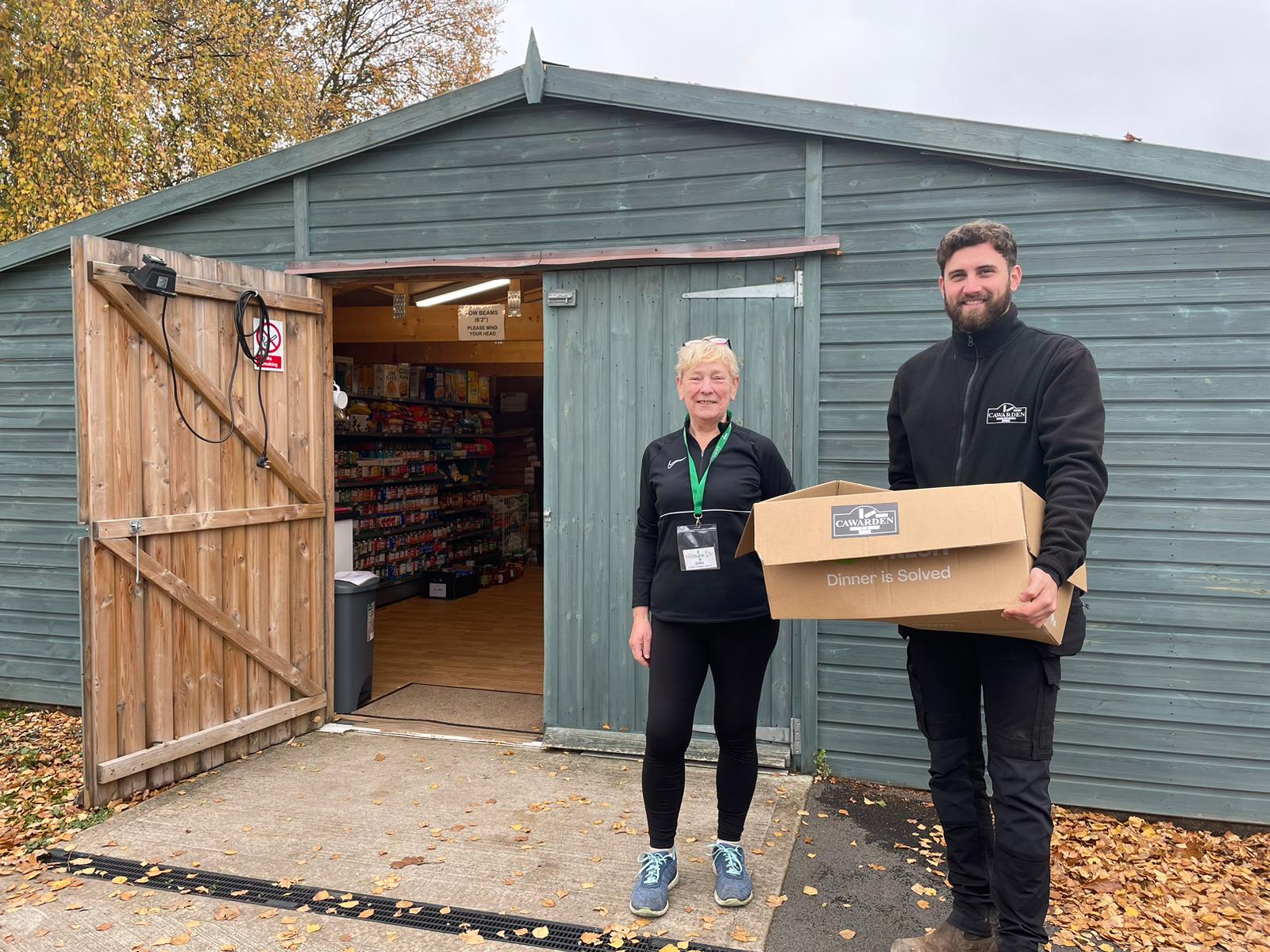 A picture of Dena Hill of Lichfield Foodbank receives a food donation from Cawarden site manager Callum Porter.