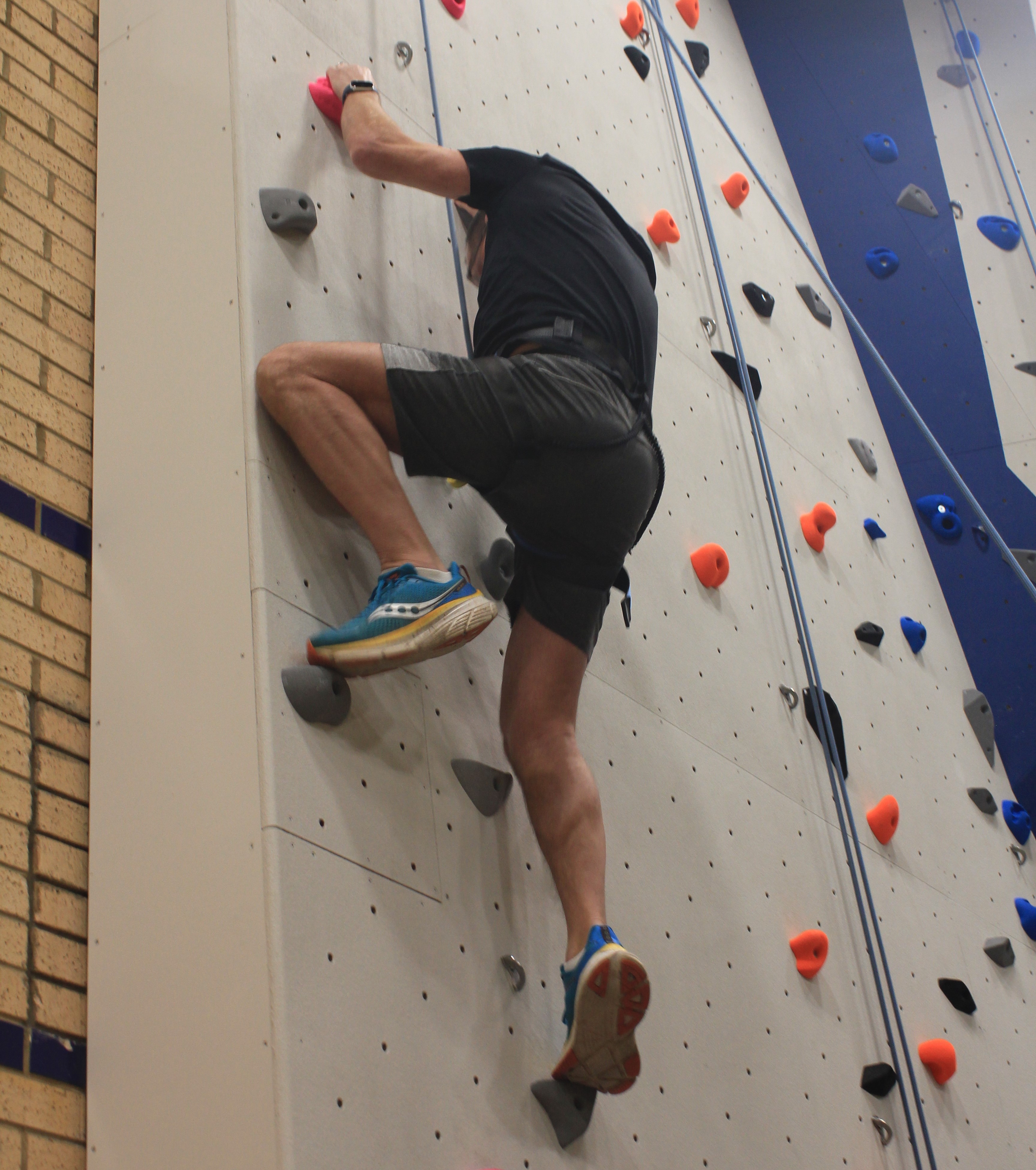 A picture of Councillor Andy Smith scaling the climbing wall.