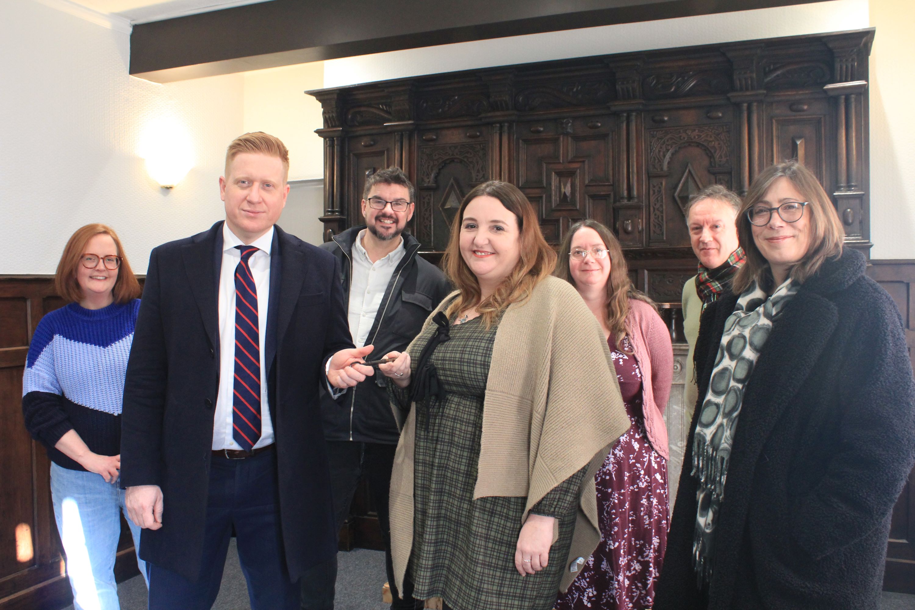 Picture of council Leader Doug Pullen presenting the key to The Schoolmaster’s House to Katie Gomez of Lichfield Discovered while fellow volunteers (from left) Morwenna Rae, John Tanner, Teresa Gilmore, John Gallagher and Jacky Billingsley look on.