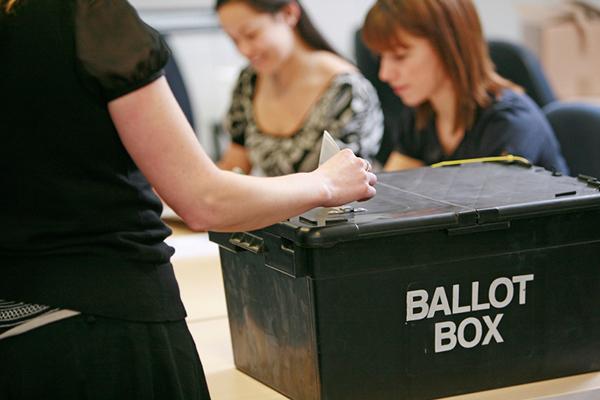woman placing vote in ballot box
